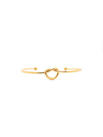 Gold bracelet with a knot design on a white background