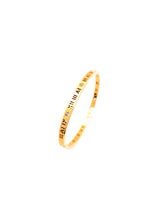 Gold bracelet with Roman numeral design on a white background