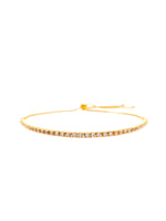Gold bracelet with clear stones on a white background