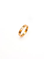 Gold ring with a subtle pattern on a white background