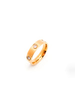 Gold ring with embedded stones on a white background