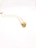 Gold necklace with a decorative clasp on a white background
