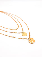 Gold necklaces with round pendants on a white background
