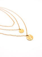 Gold necklaces with round pendants on a white background