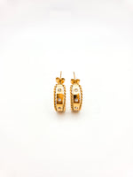 Pair of gold hoop earrings with embedded stones on a white background