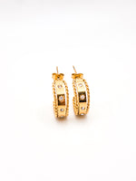 Pair of gold hoop earrings with small diamonds on a white background