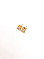 Gold square stud earrings with clear gemstones on a white background