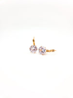 Gold earrings with clear gemstones on a white background