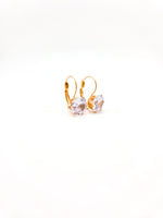 Gold earrings with clear gemstones on a white background