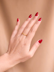 Hand with red nail polish on a beige background