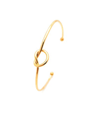 Gold knot-shaped bangle on a white background