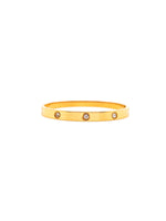 Gold bracelet with embedded stones on a white background