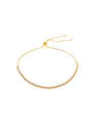 Gold beaded bracelet on a white background