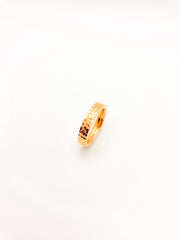 Gold ring with a textured band on a white background
