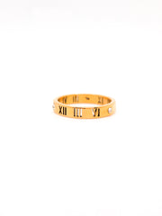 Gold ring with Roman numeral design on a white background