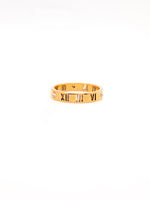 Gold bracelet with Roman numeral design on a white background