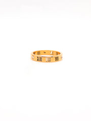 Gold bracelet with Roman numeral design on a white background