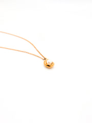 Gold necklace with a pearl pendant on a white background