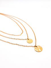 Gold necklaces with round pendants on a white background