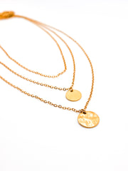 Three gold necklaces with round pendants on a white background