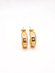 Pair of gold hoop earrings with small diamonds on a white background