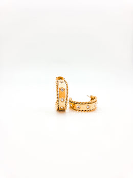 Gold hoop earrings with embedded stones on a white background