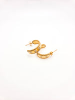 Gold hoop earrings with small diamonds on a white background