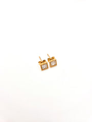 Gold square earrings with clear gemstones on a white background