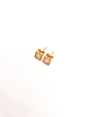 Gold square stud earrings with clear gemstones on a white background