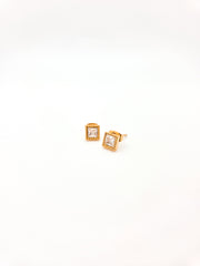 Gold square earrings with clear gemstones on a white background