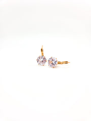 Gold earrings with clear gemstones on a white background