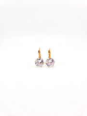 Pair of gold earrings with clear gemstones on a white background
