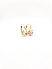 Gold earrings with clear gemstones on a white background
